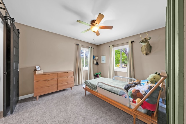 1205 Mckail Rd, Leonard, MI 48367 - bedroom with a barn door, light carpet, ceiling fan, and baseboards