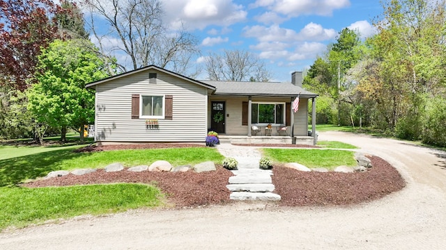 1205 Mckail Rd, Leonard, MI 48367 - ranch-style home with covered porch, a chimney, and a front yard