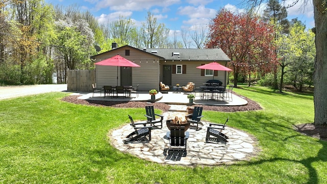 1205 Mckail Rd, Leonard, MI 48367 - rear view of house with a fire pit, a patio area, a lawn, and outdoor dining space