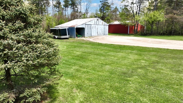 1205 Mckail Rd, Leonard, MI 48367 - view of grassy yard with an outdoor structure, driveway, and a pole building