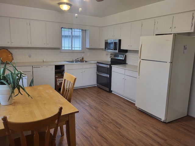 kitchen with backsplash, dark wood-style flooring, appliances with stainless steel finishes, a sink, and light countertops