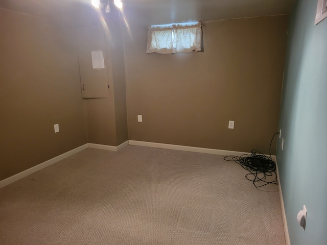 basement featuring light colored carpet and baseboards