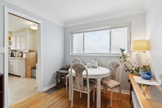 dining area with baseboards and light wood-style floors