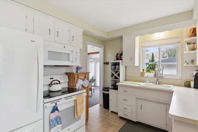 kitchen featuring light countertops, decorative backsplash, a sink, and white appliances