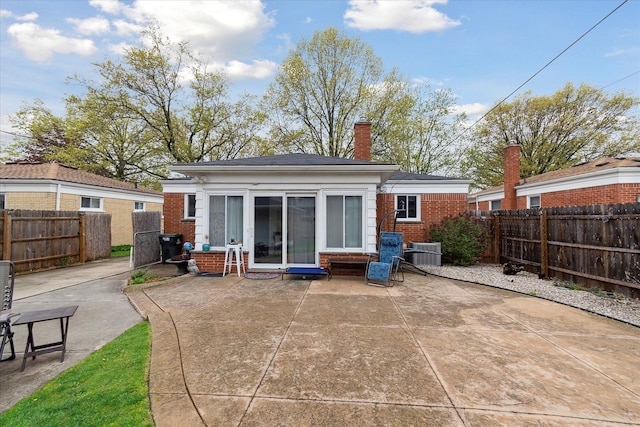 back of property featuring brick siding, a fenced backyard, and a patio area