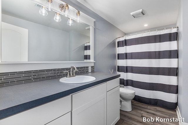 3779 Mesa Verde Dr, Hudsonville, MI 49426 - bathroom featuring vanity, toilet, wood finished floors, tasteful backsplash, and a shower with curtain