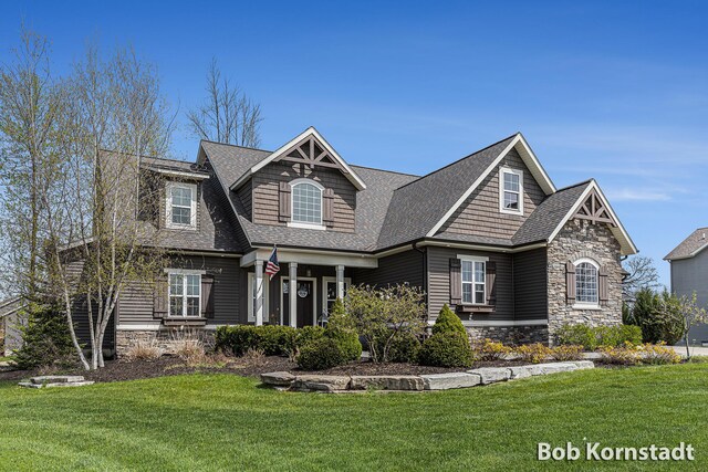3779 Mesa Verde Dr, Hudsonville, MI 49426 - craftsman-style house with a porch, a front yard, a shingled roof, and stone siding