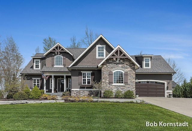 3779 Mesa Verde Dr, Hudsonville, MI 49426 - craftsman house featuring an attached garage, a front lawn, stone siding, covered porch, and driveway