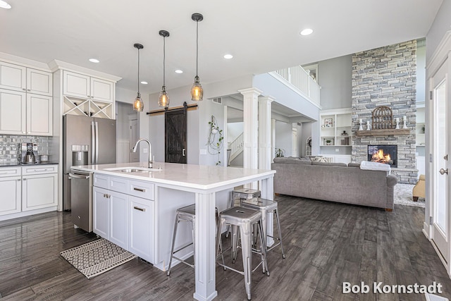 3779 Mesa Verde Dr, Hudsonville, MI 49426 - kitchen featuring stainless steel dishwasher, dark wood-style floors, a barn door, white cabinets, and a sink