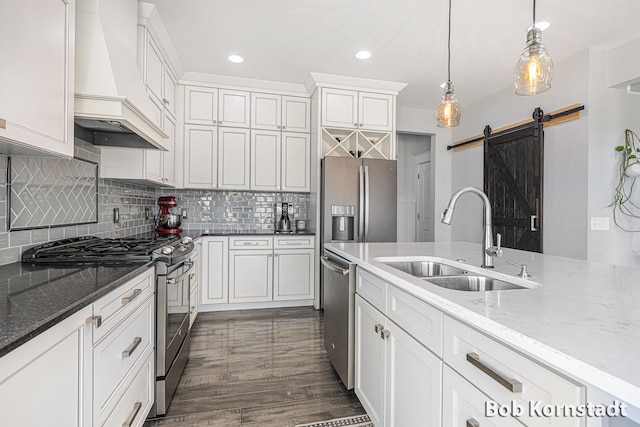 3779 Mesa Verde Dr, Hudsonville, MI 49426 - kitchen featuring a barn door, a sink, white cabinets, custom exhaust hood, and stainless steel appliances