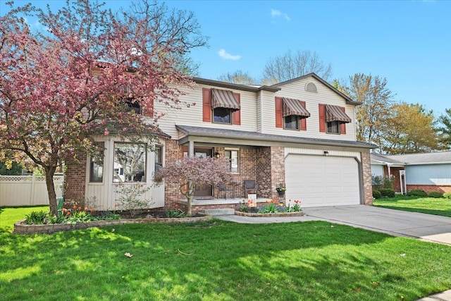 traditional-style house with fence, brick siding, a garage, a front yard, and concrete driveway