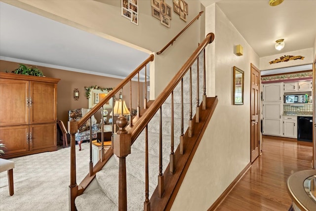 stairway with crown molding and baseboards