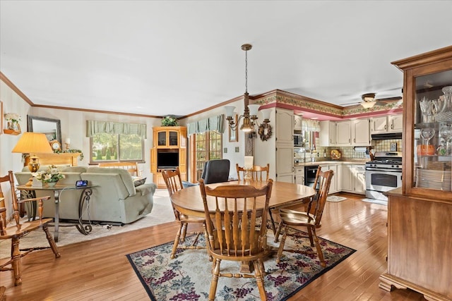 dining space with ornamental molding and light wood finished floors
