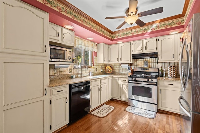 kitchen featuring a sink, stainless steel appliances, a ceiling fan, tasteful backsplash, and under cabinet range hood