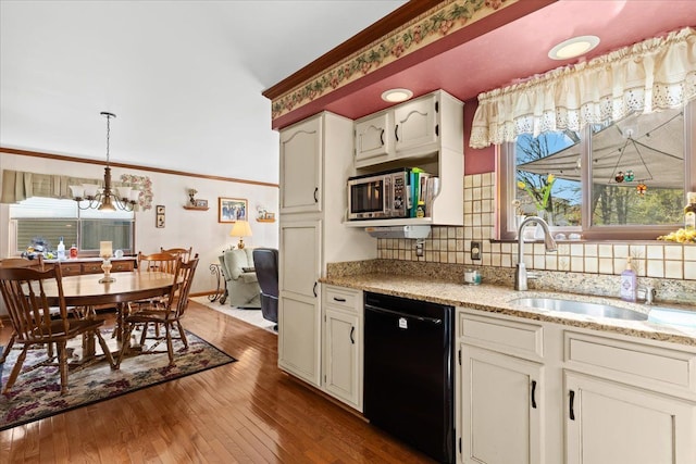 kitchen featuring ornamental molding, decorative backsplash, black dishwasher, stainless steel microwave, and hardwood / wood-style flooring