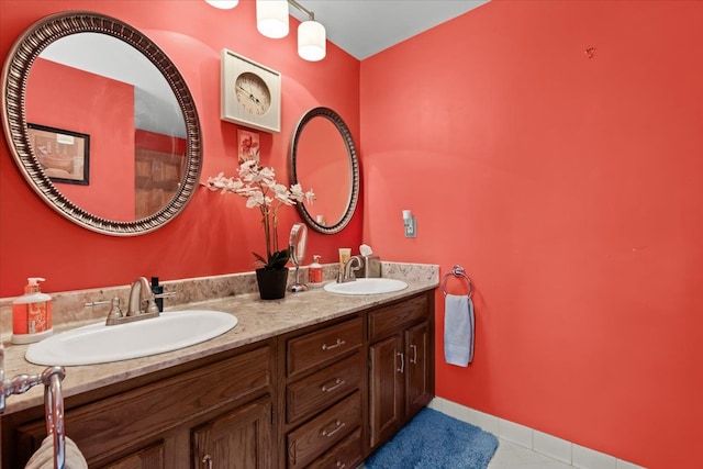 full bath with a sink, tile patterned floors, and double vanity
