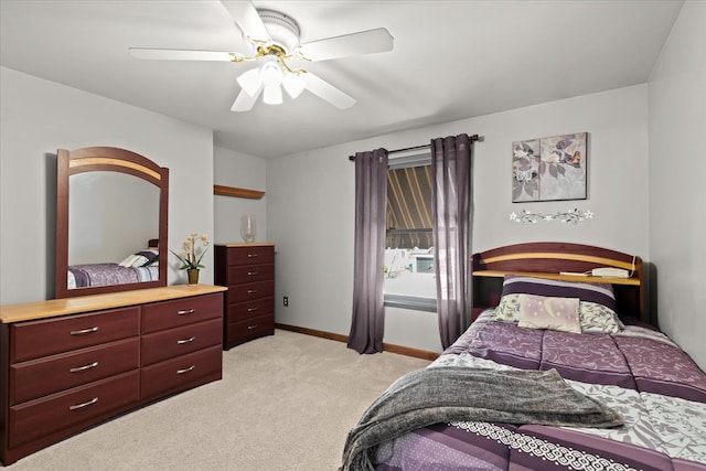 bedroom featuring baseboards, ceiling fan, and light carpet