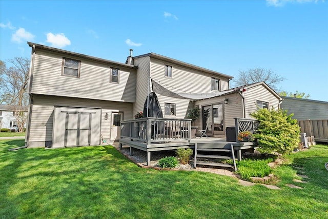 back of house featuring a wooden deck and a yard