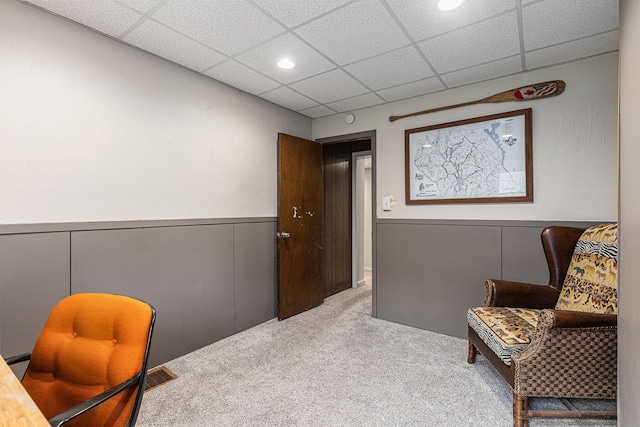 sitting room featuring recessed lighting, carpet flooring, a drop ceiling, and a wainscoted wall
