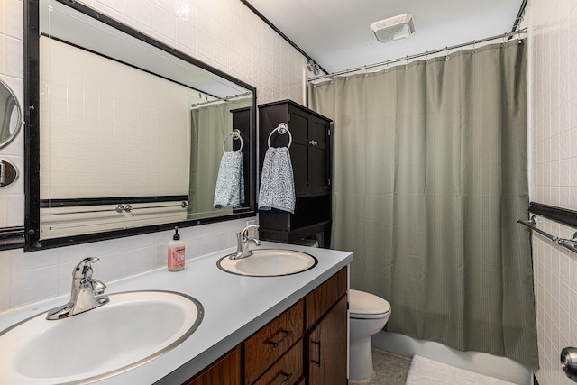 full bath featuring double vanity, toilet, tile walls, and a sink