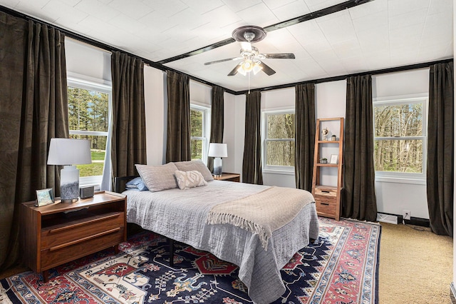 bedroom featuring carpet, ceiling fan, and multiple windows