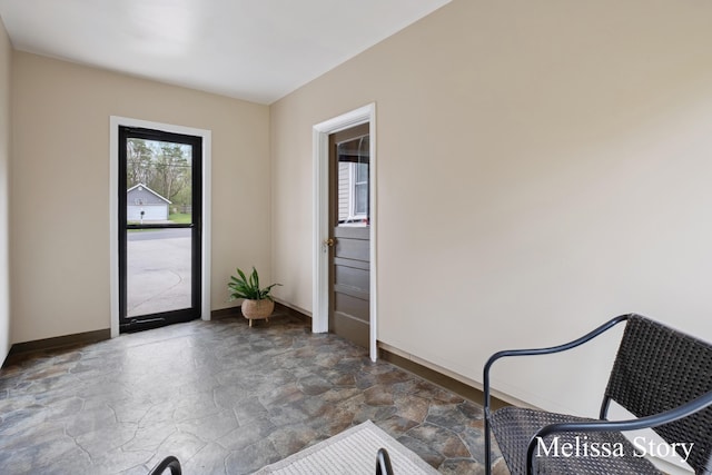 doorway featuring baseboards and stone finish flooring
