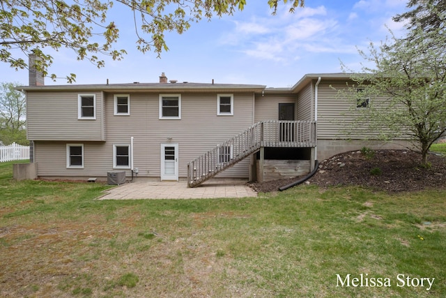back of property with a patio, a chimney, and a yard