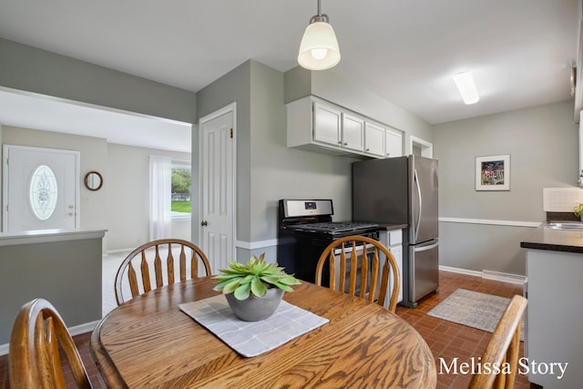 dining area with baseboards and brick floor