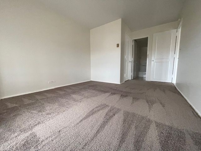 unfurnished bedroom with baseboards and carpet flooring