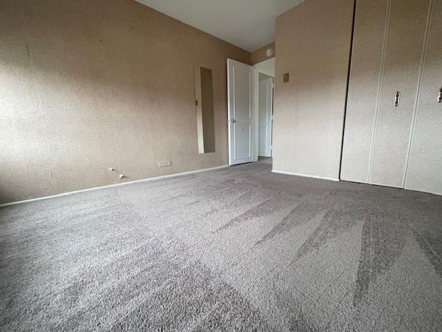 unfurnished bedroom with a closet, carpet, and baseboards