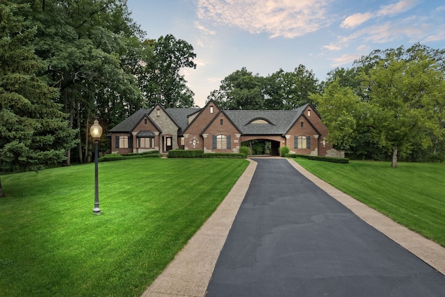 11599 Erins Way, Romeo, MI 48065 - french country style house with brick siding, a front yard, and driveway