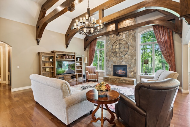 11599 Erins Way, Romeo, MI 48065 - living area with arched walkways, a stone fireplace, a chandelier, high vaulted ceiling, and baseboards