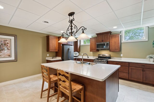 11599 Erins Way, Romeo, MI 48065 - kitchen featuring appliances with stainless steel finishes, a sink, light countertops, a breakfast bar, and an island with sink