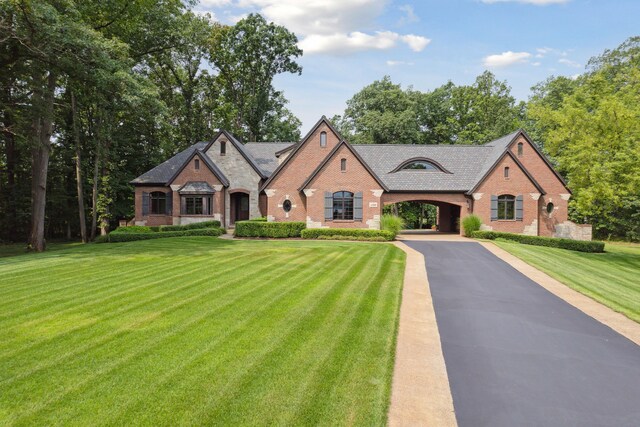 11599 Erins Way, Romeo, MI 48065 - french country style house with brick siding, driveway, a front lawn, and a carport