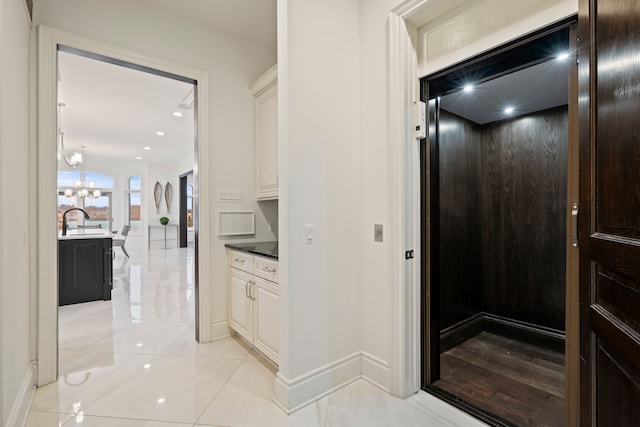 5820 Lakeview Ave, Orchard Lake, MI 48323 - hallway featuring baseboards, a notable chandelier, and elevator