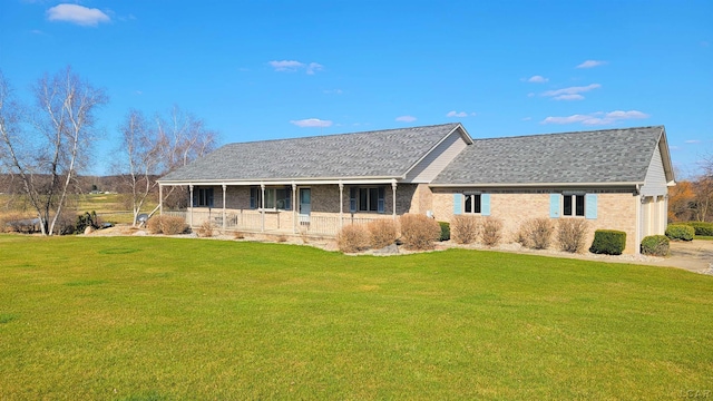 ranch-style home with a porch, brick siding, roof with shingles, and a front yard