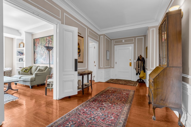entryway featuring a decorative wall, wood finished floors, and crown molding
