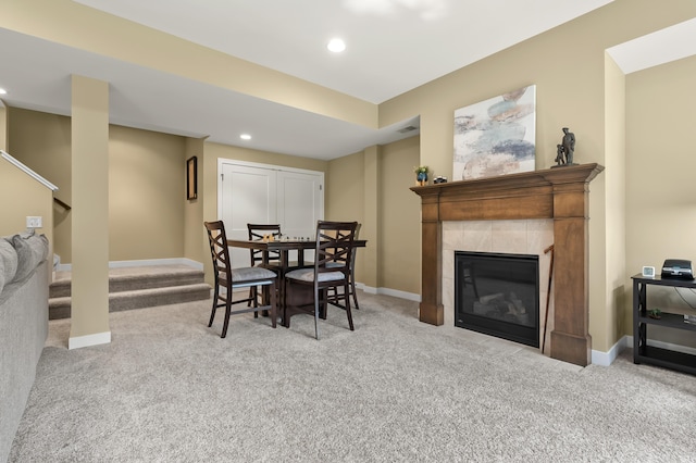 carpeted dining area featuring stairway, baseboards, recessed lighting, and a tile fireplace