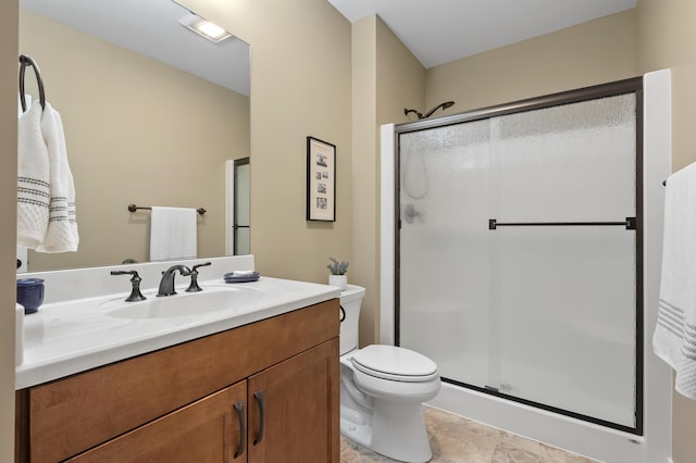 bathroom featuring vanity, toilet, and a shower stall