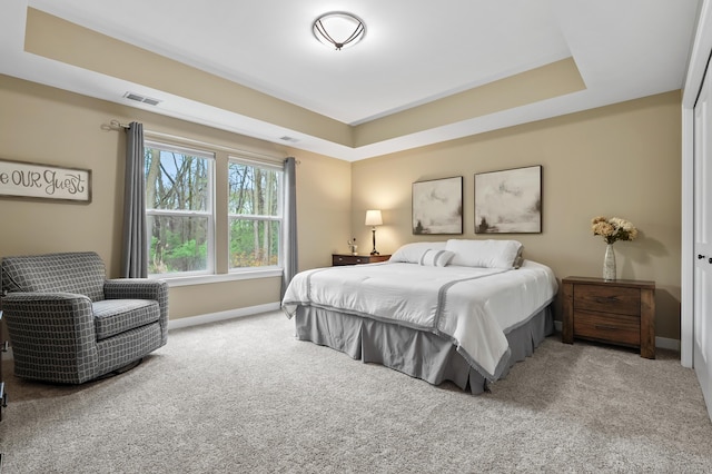bedroom with visible vents, a raised ceiling, carpet, and baseboards