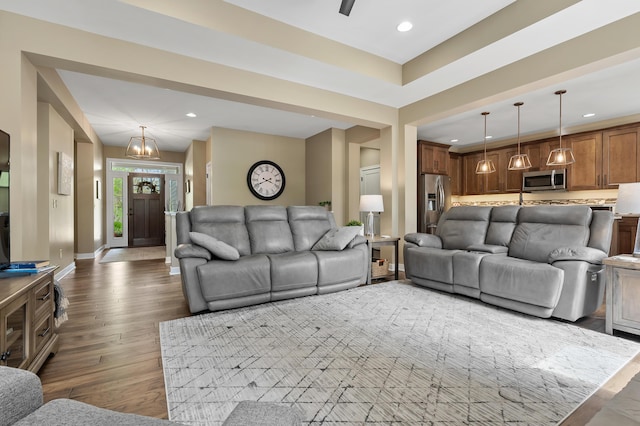 living room with recessed lighting, baseboards, wood finished floors, and a notable chandelier