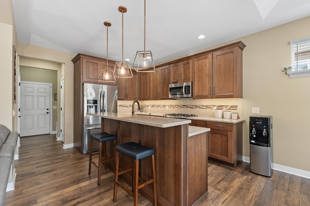 kitchen with dark wood-style flooring, tasteful backsplash, a breakfast bar, and stainless steel appliances