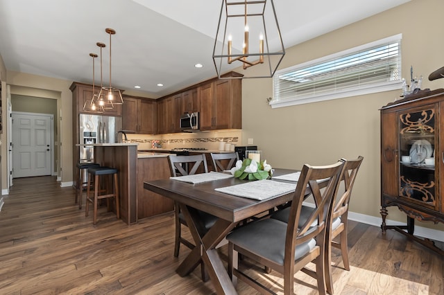 dining space featuring baseboards, recessed lighting, a chandelier, and dark wood-style floors