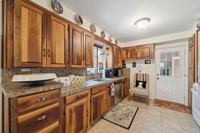 kitchen featuring a sink, stainless steel appliances, brown cabinets, and light tile patterned flooring