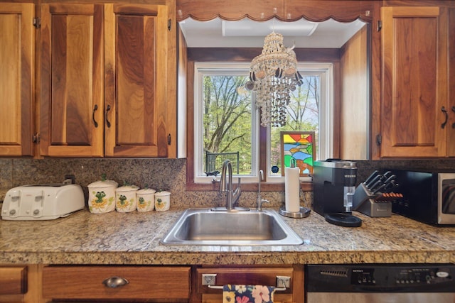 kitchen featuring a sink, a notable chandelier, dishwasher, and brown cabinets