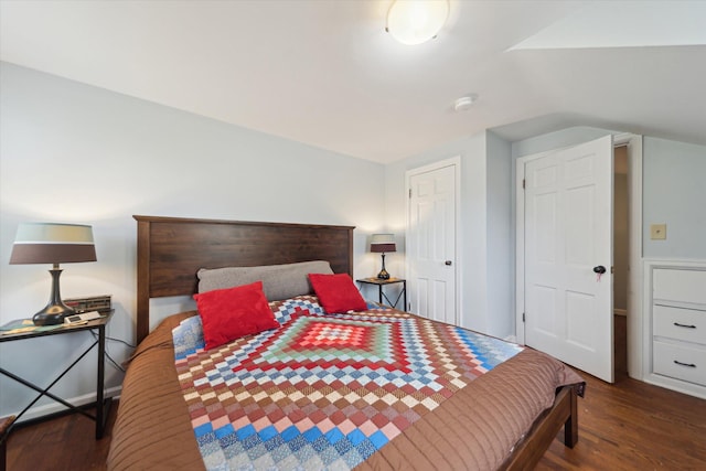 bedroom with vaulted ceiling and wood finished floors