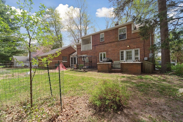 back of property featuring brick siding, a lawn, fence, and a chimney