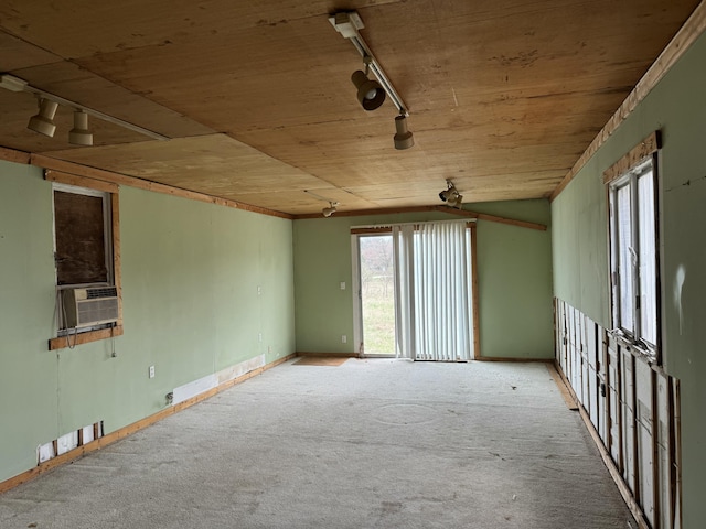 carpeted spare room featuring baseboards, rail lighting, wood ceiling, and cooling unit