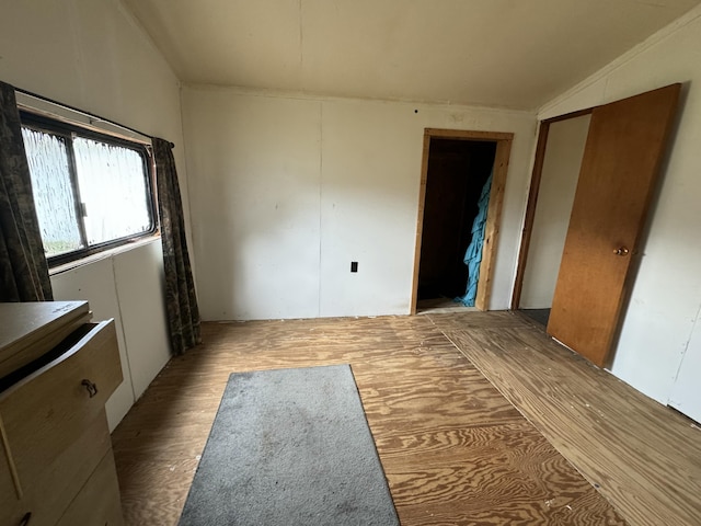 unfurnished bedroom featuring vaulted ceiling and wood finished floors
