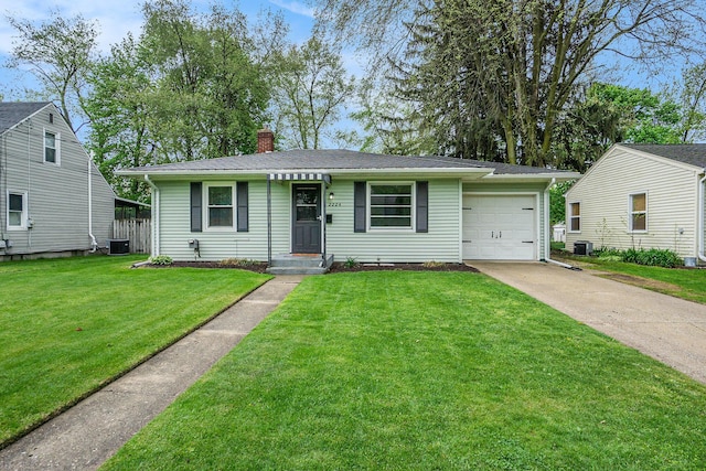 view of front facade with a chimney, a garage, cooling unit, a front lawn, and concrete driveway